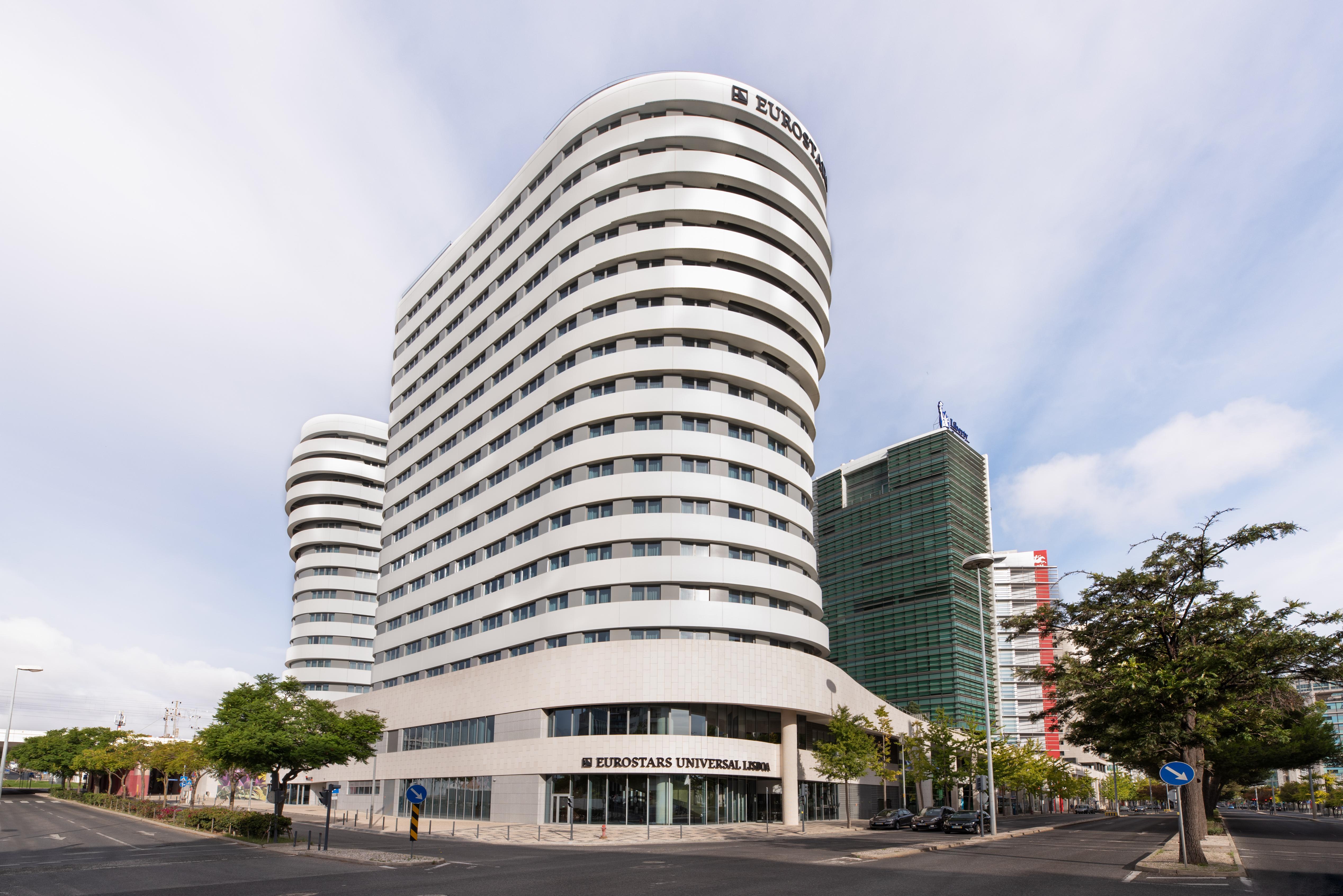 Eurostars Universal Lisboa Dış mekan fotoğraf The image shows a modern building with a distinctive architectural design. The structure features a series of curved and wavy lines, giving it a sleek and contemporary look. The façade is primarily white with large windows, which offer plenty of natu