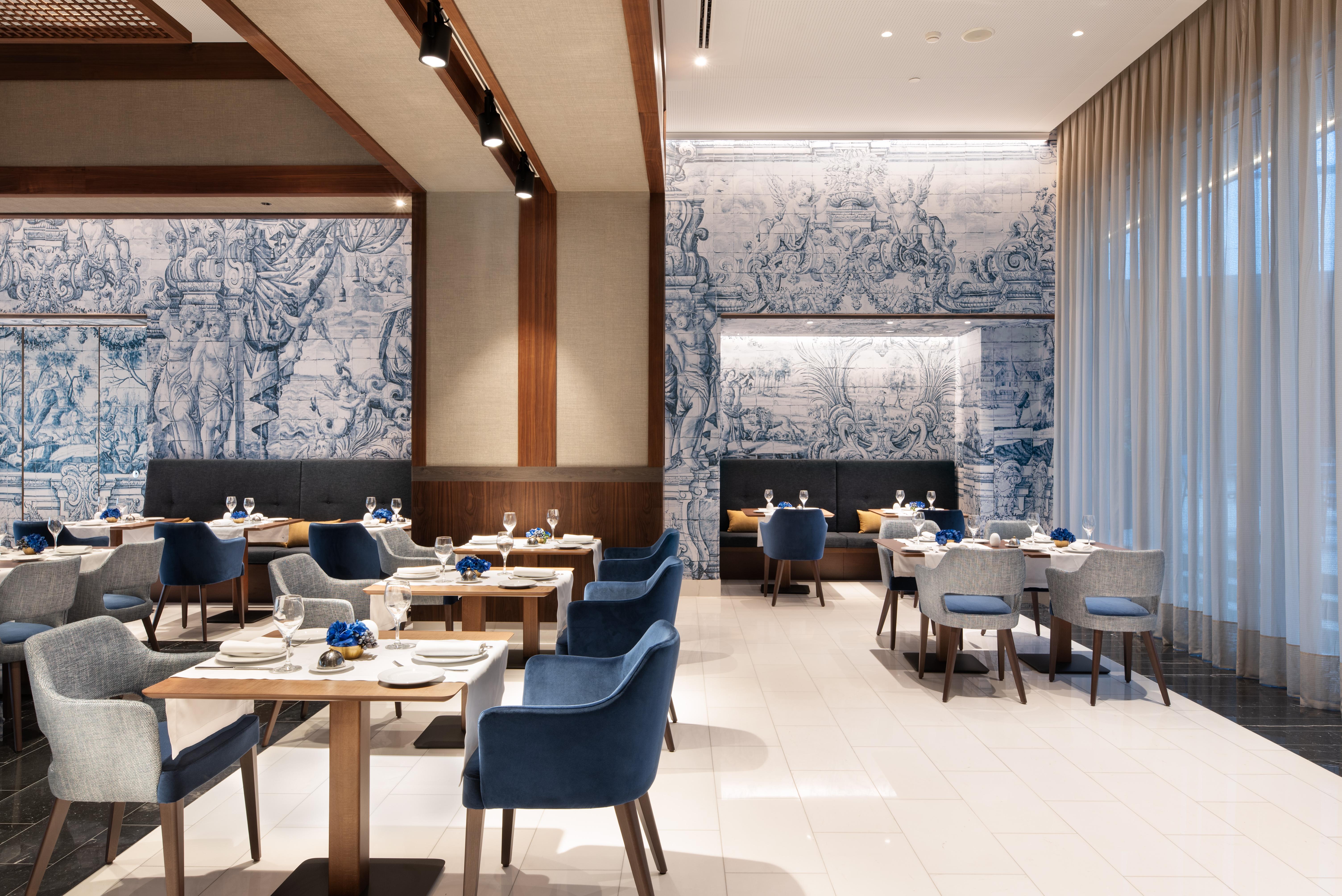 Eurostars Universal Lisboa Dış mekan fotoğraf The photo shows the interior of a modern restaurant. The space features a clean and elegant design, with wooden beams and a light color palette. The walls are adorned with intricate blue and white artwork, creating a sophisticated atmosphere. 

In th